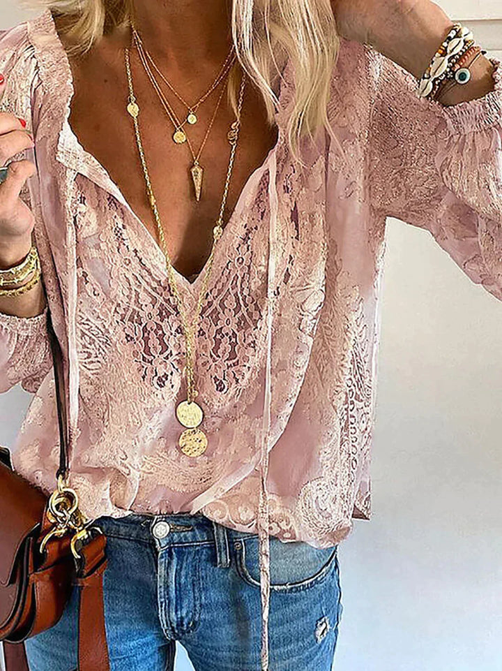 Frau in rosa Spitzenbluse, Jeans und Schmuck, modisches Outfit, lässiger Stil.