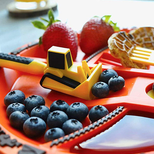 Spielzeug-Bagger auf rotem Teller mit Blaubeeren, Erdbeeren und Waffel, Kinderfrühstück.