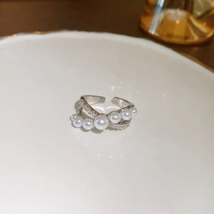 Silberner Ring mit Perlen und Strasssteinen, elegantes Schmuckdesign, modisches Accessoire.