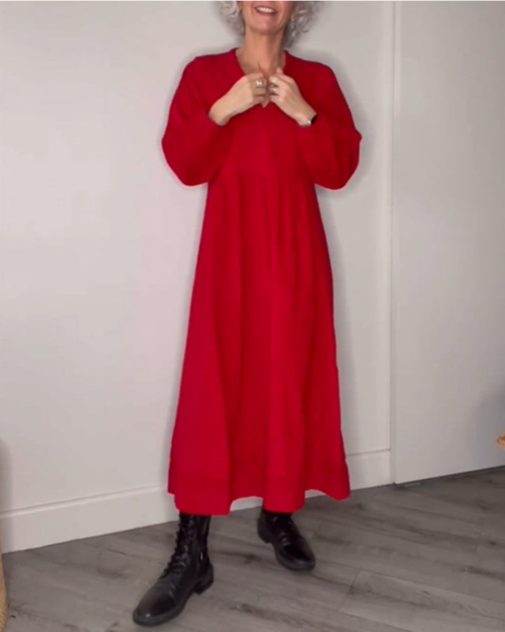 Frau in rotem Maxikleid und schwarzen Stiefeln, lächelnd, moderne Mode, Holzboden.