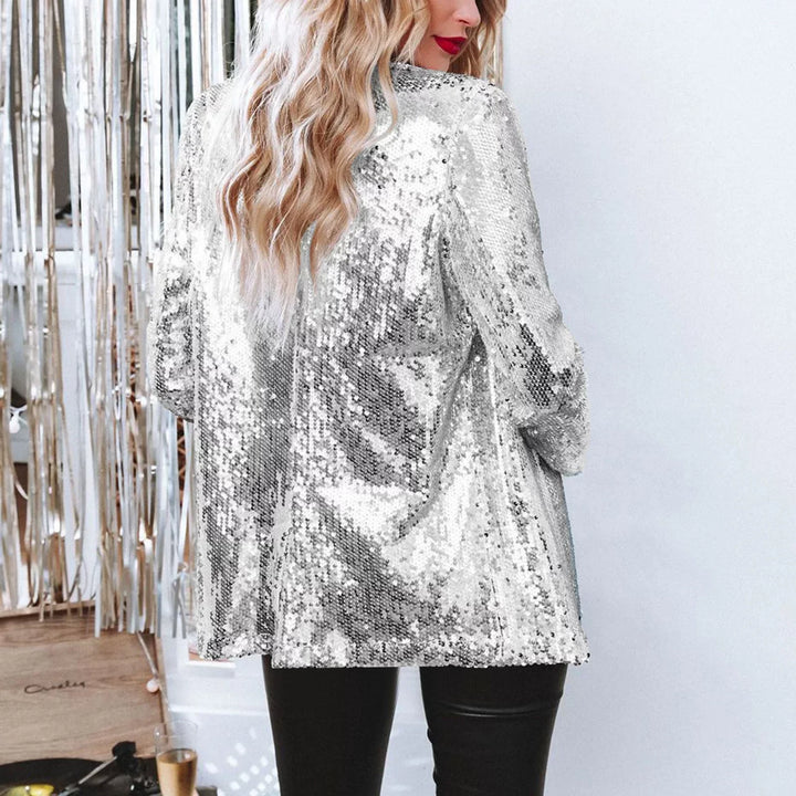 Frau in silbernem Paillettenblazer, blonde Haare, schwarze Lederhose, festliche Mode.