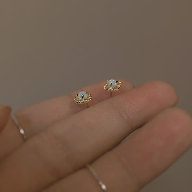 Opal Ohrringe auf Hand, goldfarben, zierlich, Schmuck, Damenaccessoire, elegantes Design.