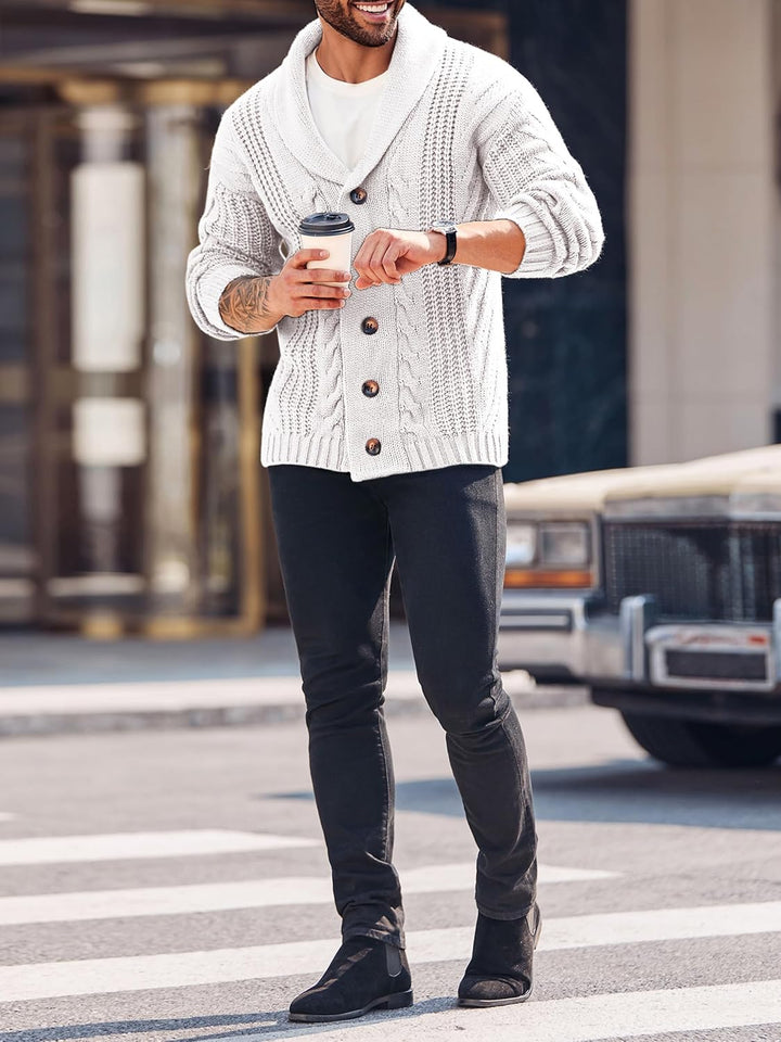 Mann in weißem Strickcardigan mit Kaffeebecher, schwarze Jeans, Straße, Herbstmode.