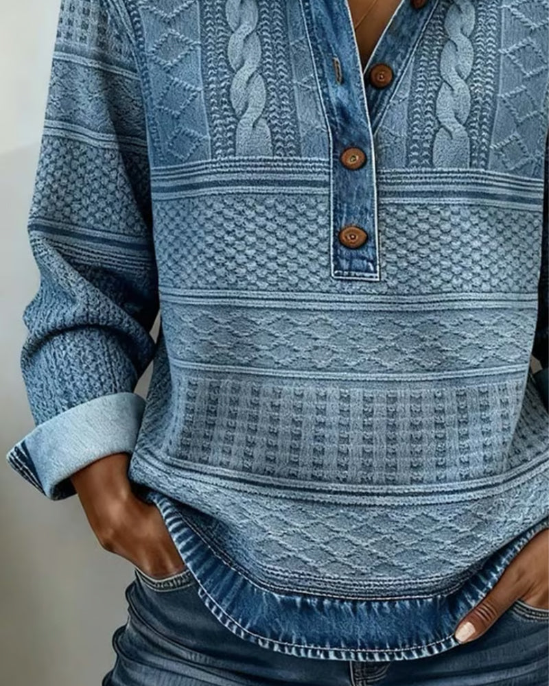 Detail modrého svetru na modelce: tři hnědé knoflíky, copánkový vzor a džínový lem 2
