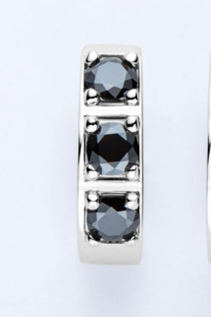 Silberner Ring mit drei schwarzen Diamanten, elegantes Schmuckdesign, luxuriöses Accessoire.
