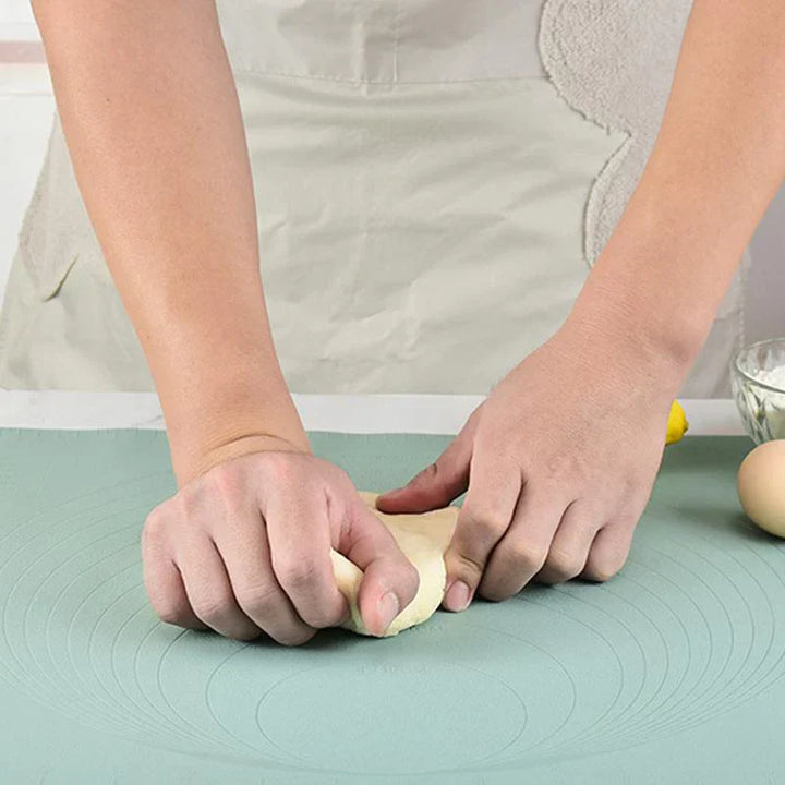 Person knetet Teig auf grüner Silikon-Backmatte, ideal für Backen und Teigzubereitung.