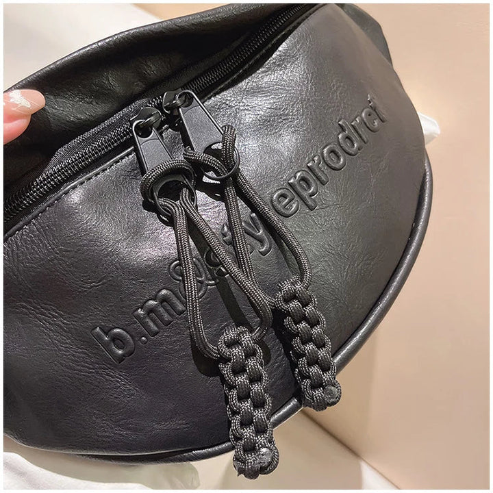 Schwarze Leder-Bauchtasche mit Reißverschluss und geprägtem Logo, modisch und praktisch.