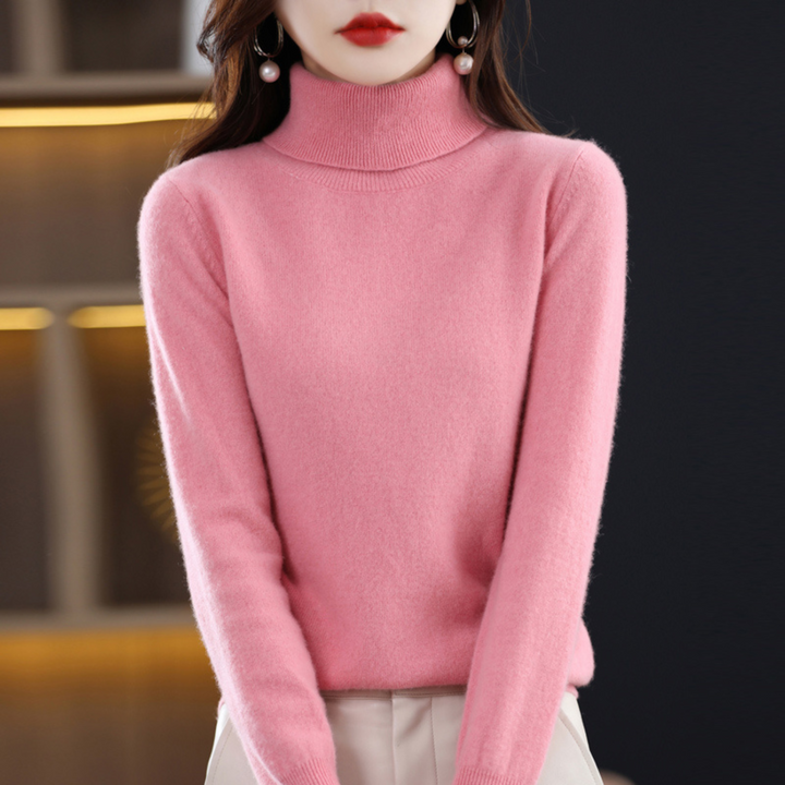 Růžový rolák na modelce stojící s rukama podél těla, kombinovaný se světlými kalhotami. 7