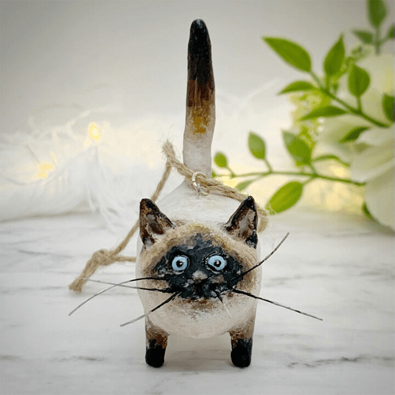 Handgefertigte Katzenfigur aus Keramik, schwarz-weiß, mit Schnur, auf Marmortisch, Dekoration.