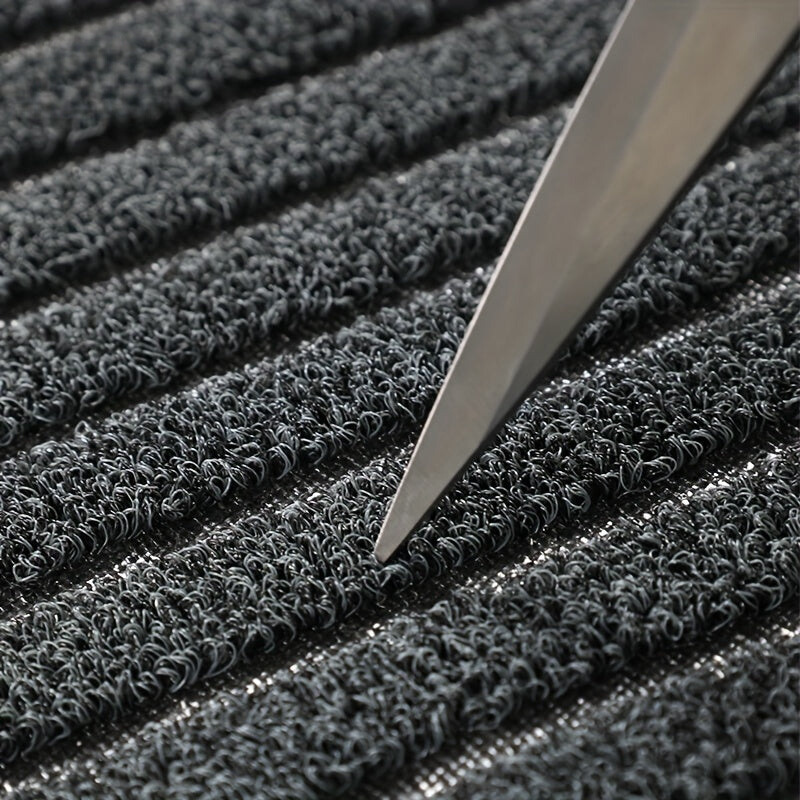 Nahaufnahme grauer Teppich mit rutschfester Oberfläche und Messer, strapazierfähig, langlebig.