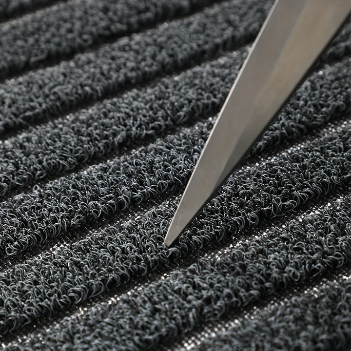 Nahaufnahme grauer Teppich mit rutschfester Oberfläche und Messer, strapazierfähig, langlebig.