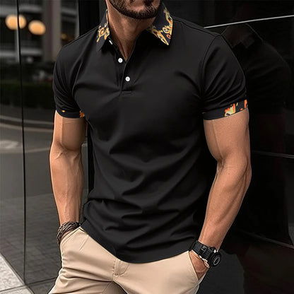 Mann in schwarzem Polohemd mit gemustertem Kragen, beige Hose, Armbanduhr, urbaner Hintergrund.