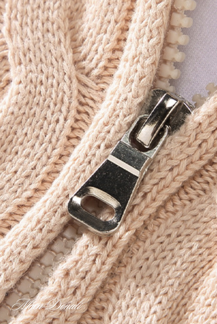 Beiger Strickpullover mit silbernem Reißverschluss, Nahaufnahme, Textilmode, Detailansicht.