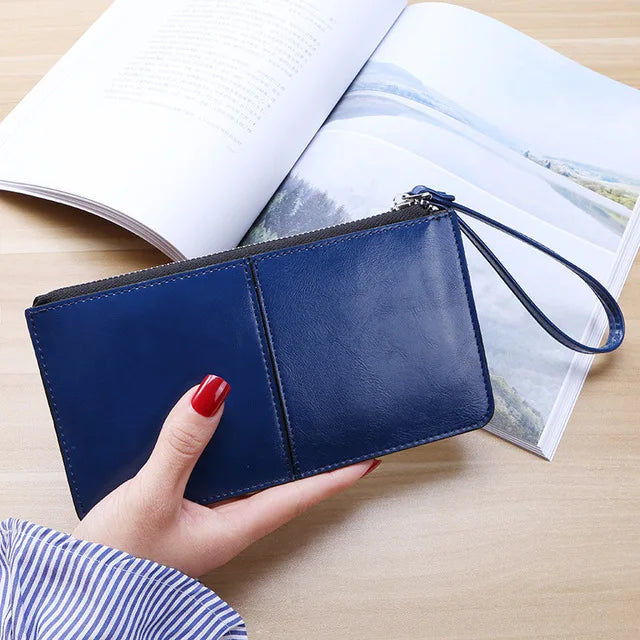 Damenhandtasche aus blauem Leder mit Reißverschluss, elegant, modisch, auf Holztisch.