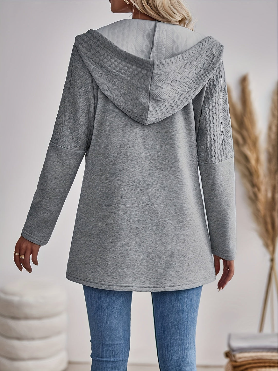 Frau in grauem Kapuzenpullover aus Strickstoff, Rückansicht, lässige Mode, Herbstkleidung.