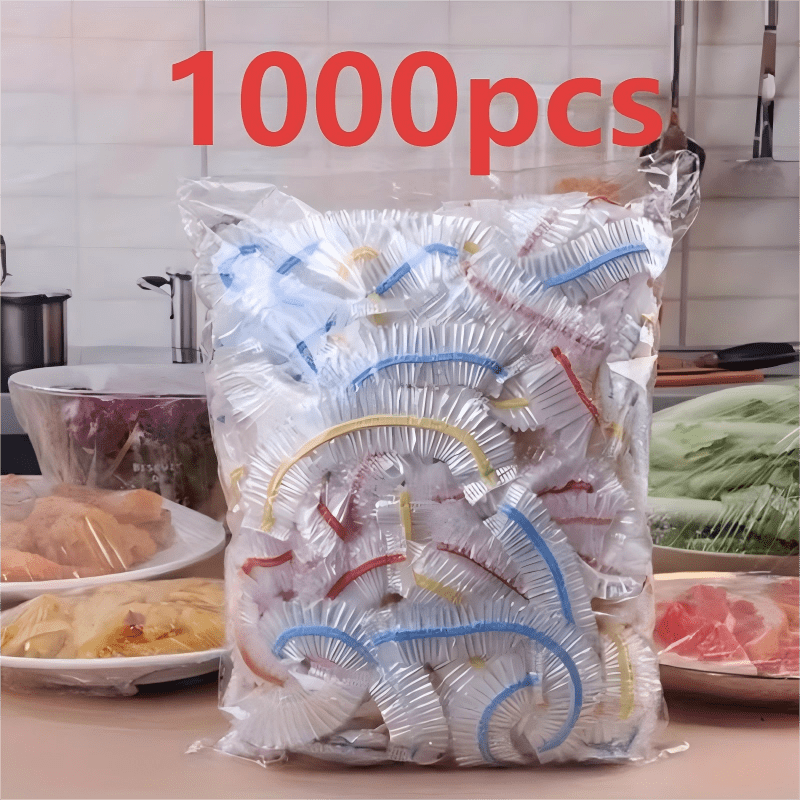 Sáček plný barevně pruhovaných elastických krytů na kuchyňské lince vedle misek s jídlem přikrytých fólií. 3