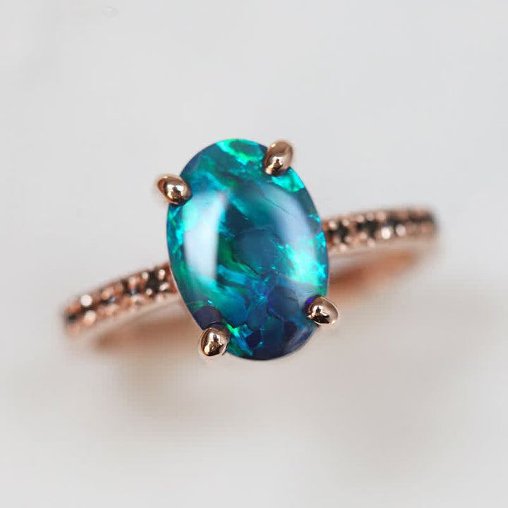 Opalring mit blau-grünem Edelstein, Roségoldfassung, eleganter Schmuck, Damenring.