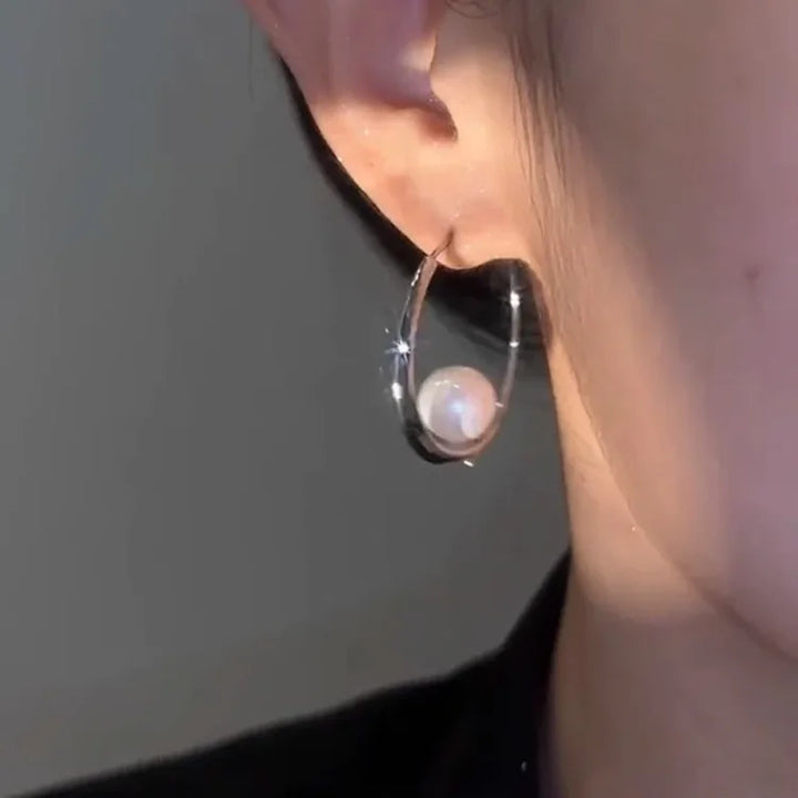 Silberner Ohrring mit Perle, eleganter Schmuck, modisches Accessoire für Damen.