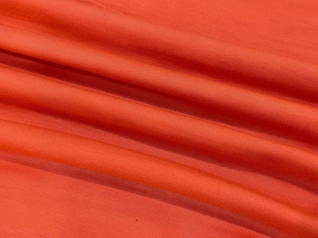 Orangefarbener Baumwollstoff, weicher Textilstoff, ideal für Kleidung und Dekoration.