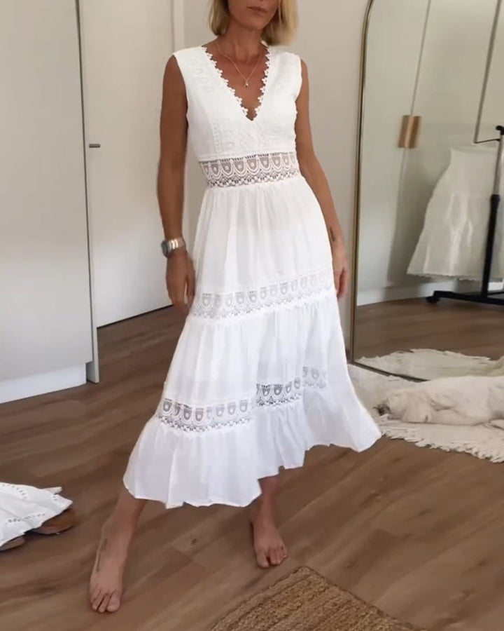 Frau in weißem Spitzenkleid, ärmellos, knielang, Sommermode, Holzfußboden, Spiegel im Hintergrund.