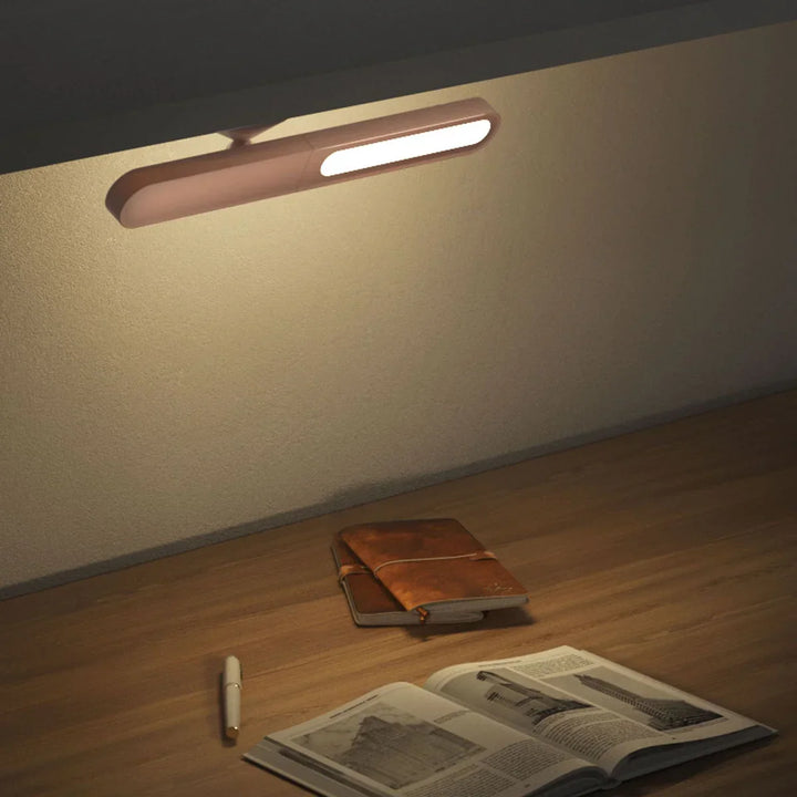 LED-Wandleuchte in modernem Design beleuchtet Schreibtisch mit Buch und Notizbuch, warmweißes Licht.