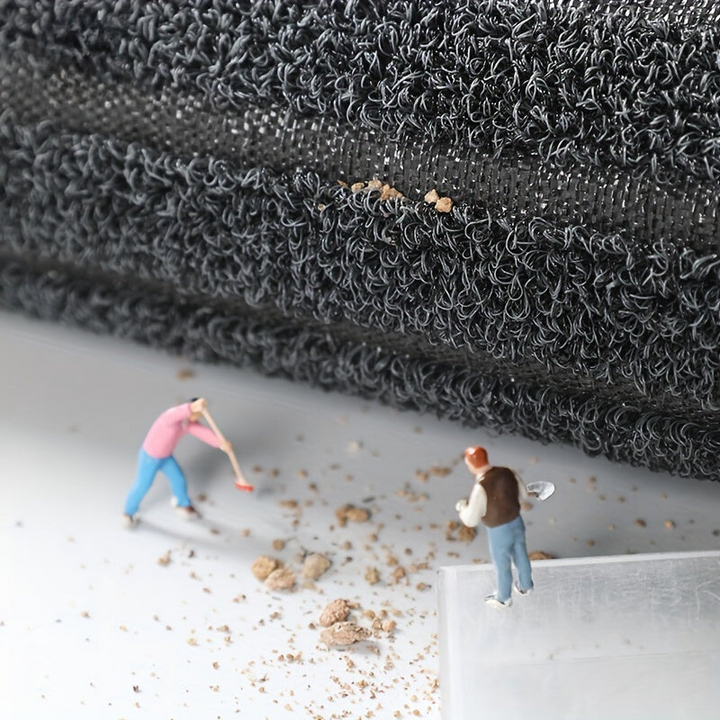 Miniaturfiguren reinigen schwarzen Teppich, Nahaufnahme, Detailansicht, Modellbau, Staubentfernung.