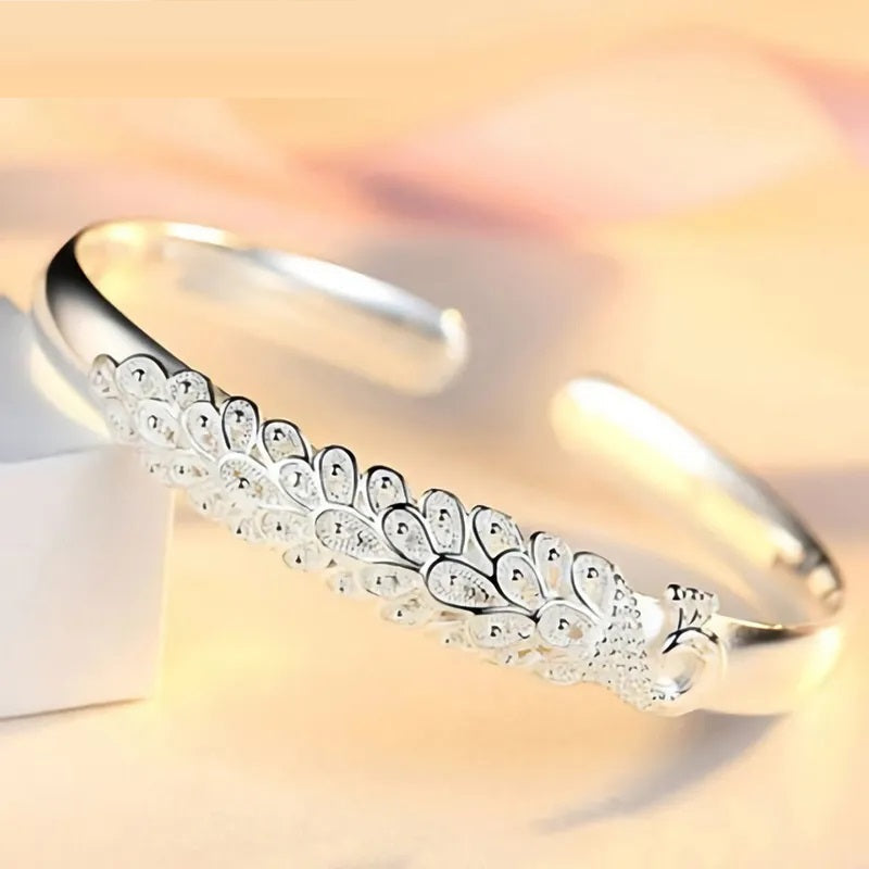 Silbernes Armreif mit Pfauenmuster, elegantes Schmuckdesign, Damenarmband, Geschenkidee.