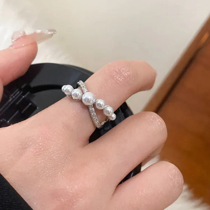 Silberring mit Perlen und Strasssteinen auf Hand, eleganter Schmuck, Damenmode Accessoire.