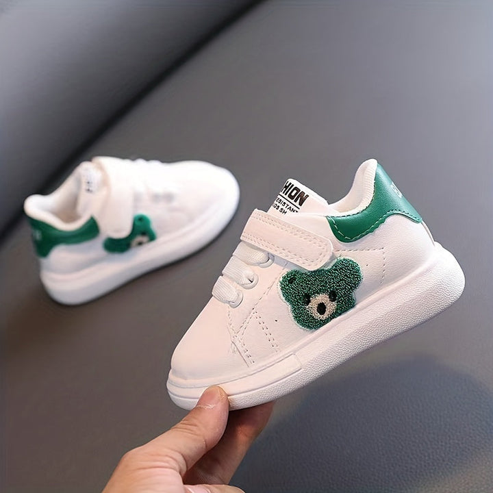 Weiße Kinderschuhe mit grünem Blumenmuster, Klettverschluss, Ledermaterial, modisch.