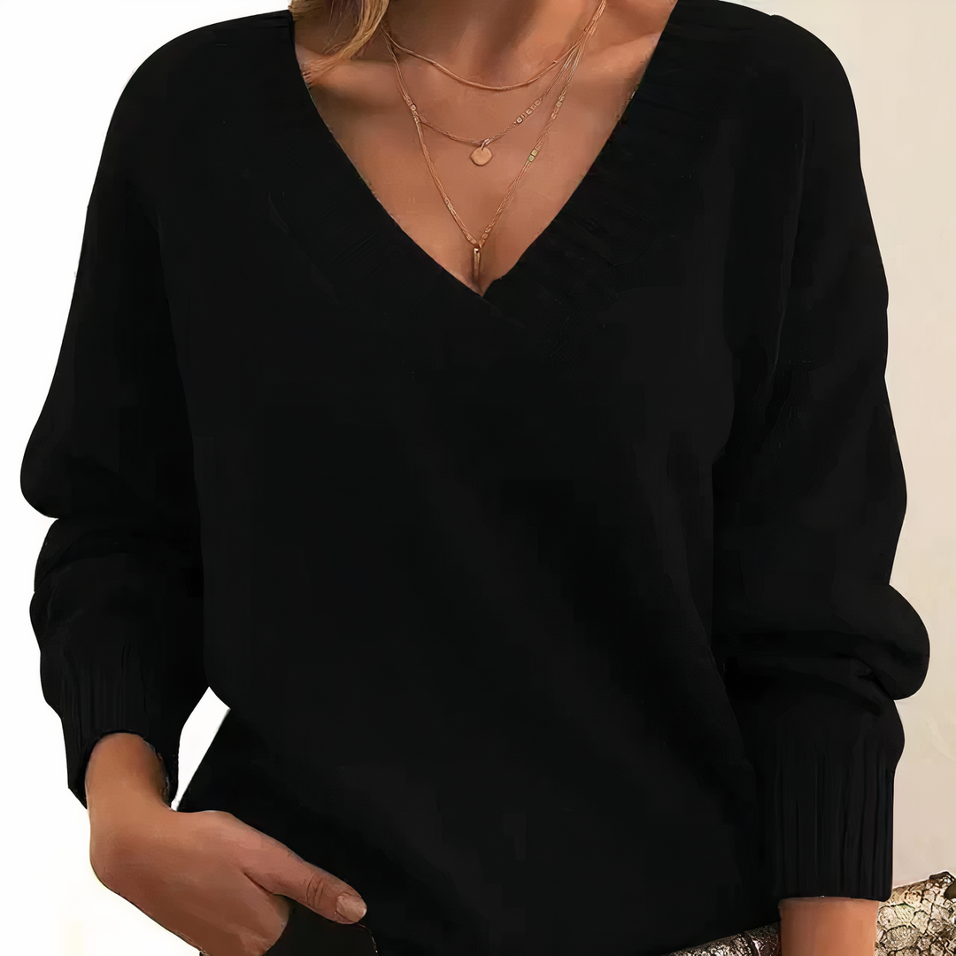 Frau in schwarzem Pullover mit V-Ausschnitt und goldener Halskette, Herbstmode Damenbekleidung.