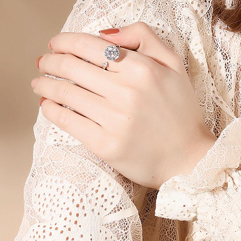 Frau mit elegantem Silberring, großer runder Diamant, Spitzenbluse, stilvoller Schmuck.