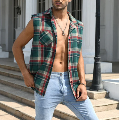Mann in ärmellosem kariertem Hemd und Jeans vor einem Gebäude mit Säulen.