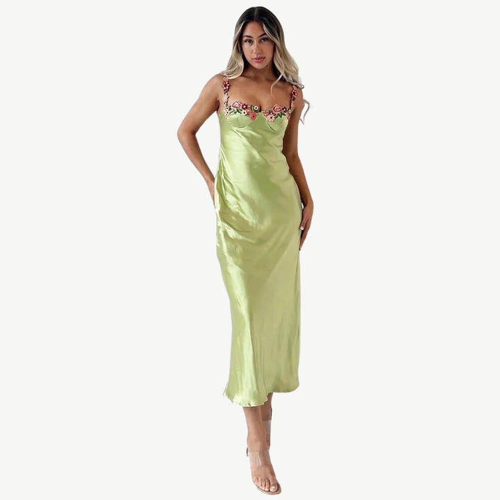Frau in grünem Satin-Slip-Kleid mit Blumenmuster, elegantes Abendkleid, Modefotografie.