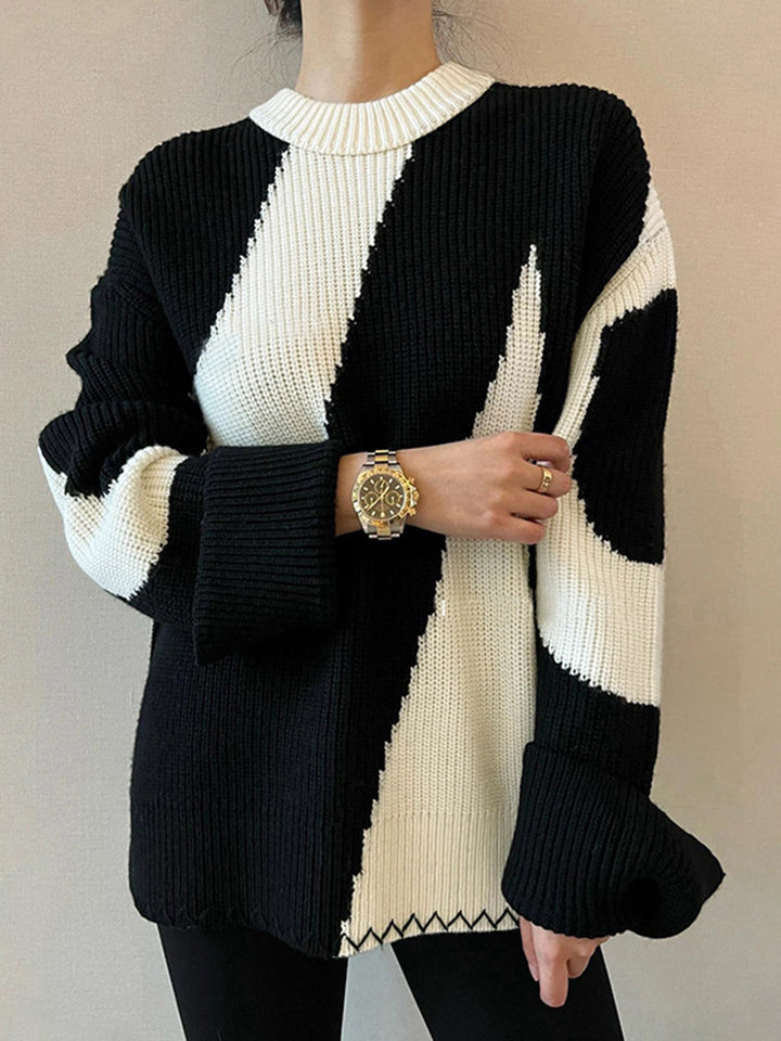 Frau trägt schwarz-weißen Strickpullover, Armbanduhr, modisch, Herbstmode, Damenbekleidung.