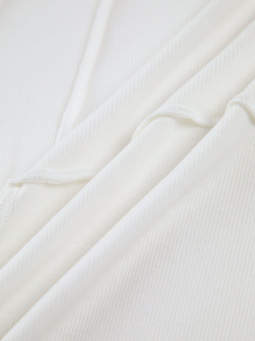 Weiße Baumwollstoff, Nahaufnahme, weiche Textur, hochwertiges Material, ideal für Kleidung.