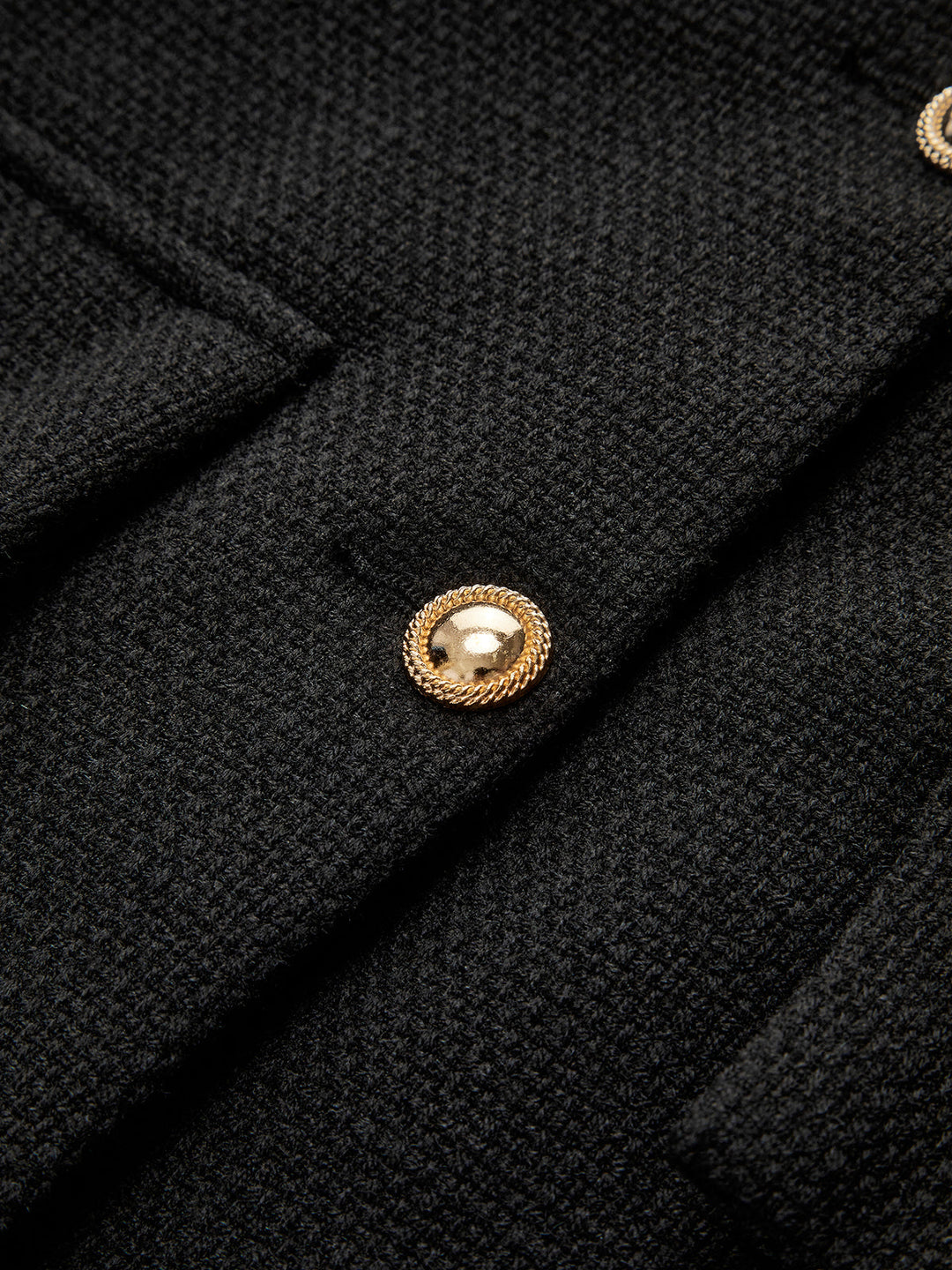 Schwarzer Wollmantel mit goldenen Knöpfen, elegantes Design, hochwertige Damenmode.