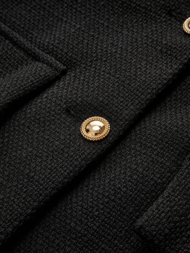 Schwarzer Wollmantel mit goldenen Knöpfen, elegantes Design, hochwertige Damenmode.