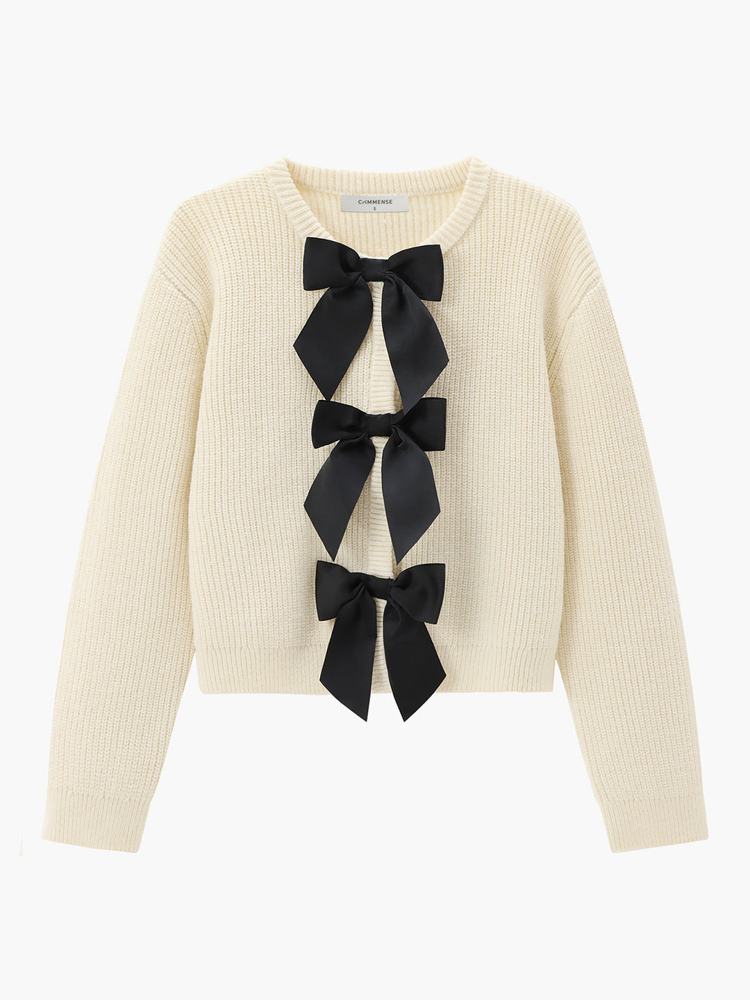 Cremefarbener Strickpullover mit schwarzen Schleifen, Damenmode, eleganter Herbst-Look.