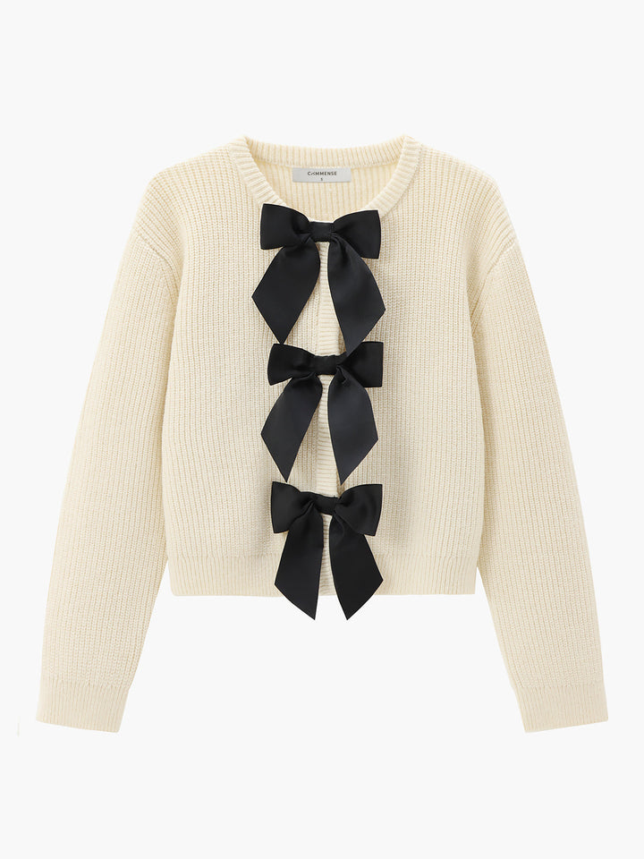 Cremefarbener Strickpullover mit schwarzen Schleifen, Damenmode, eleganter Herbst-Look.