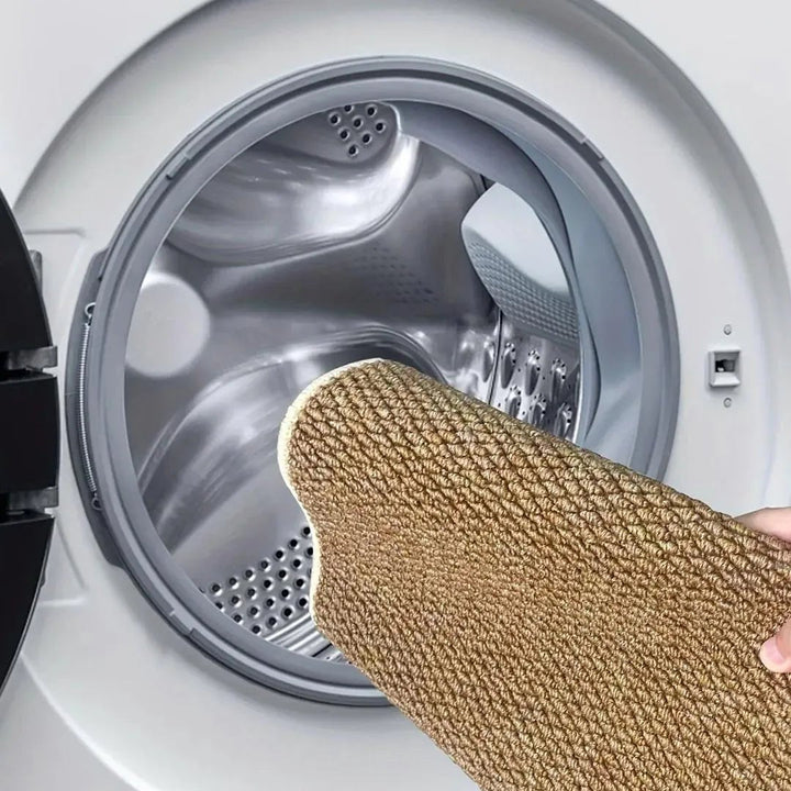 Ruka drží hnědou předložku před otevřeným bubnem pračky, ukázka praní v automatické pračce 7