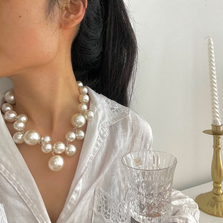 Frau trägt elegante Perlenkette, weiß, Brautschmuck, Halskette, Damenmode, stilvoll.