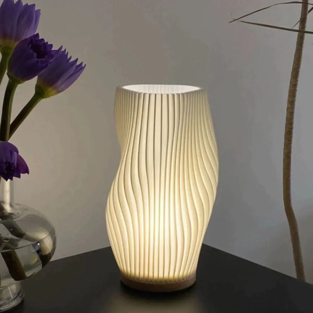Moderne weiße Tischlampe mit wellenförmigem Design, ideal für stilvolle Wohnraumbeleuchtung.