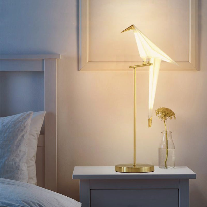 Goldene Vogel-Tischlampe auf Nachttisch, modernes Design, Schlafzimmerbeleuchtung.