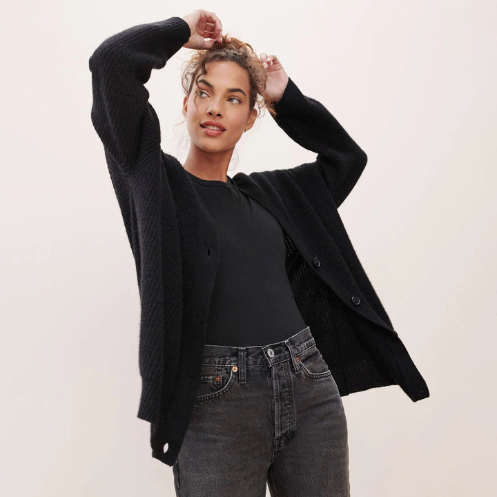 Frau in schwarzem Strickcardigan und Jeans, modisch, lässig, Herbstmode, Damenbekleidung.