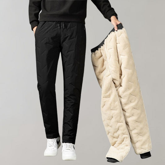 Mann in schwarzer Stepphose hält beige Fleecehose, Wintermode, Herrenbekleidung.