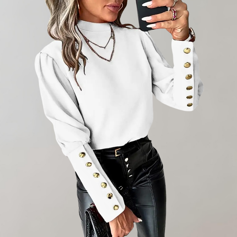 Frau in weißer Bluse mit goldenen Knöpfen, schwarze Lederhose, modisches Outfit.
