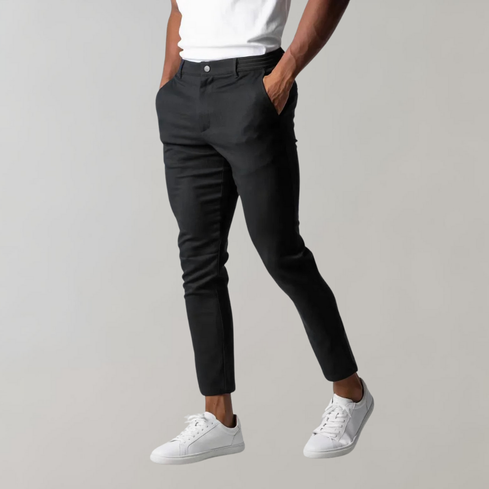 Schwarze Chinohose für Herren, Slim Fit, Baumwolle, elegant, modern, mit weißen Sneakern.