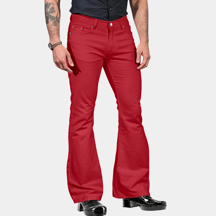 Mann in roten Schlaghosen, schwarze Schuhe, tätowierter Arm, modische Herrenbekleidung.