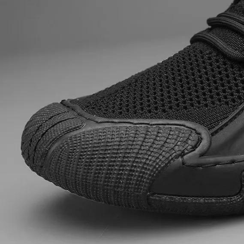 Schwarzer Sneaker aus Mesh und Gummi, seitliche Nahaufnahme, sportlich, modern, atmungsaktiv.