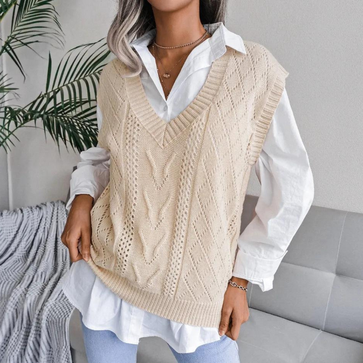 Frau trägt apricotfarbene Strickweste über weißer Bluse, modisch, elegant, Herbstmode.